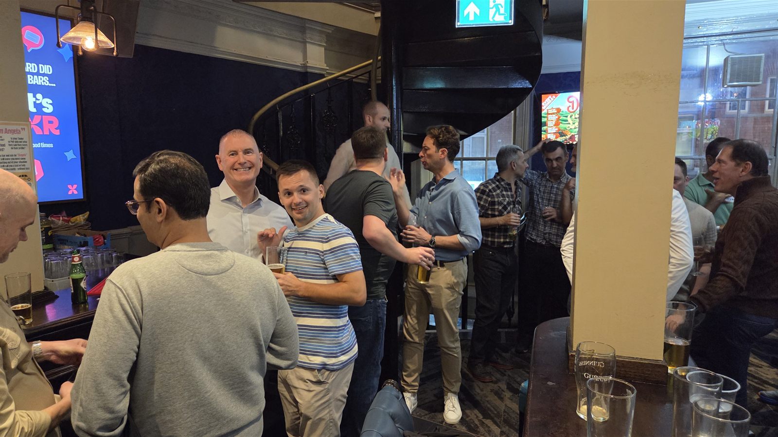 London Gays members chatting by the staircase at the Duke of Wellington